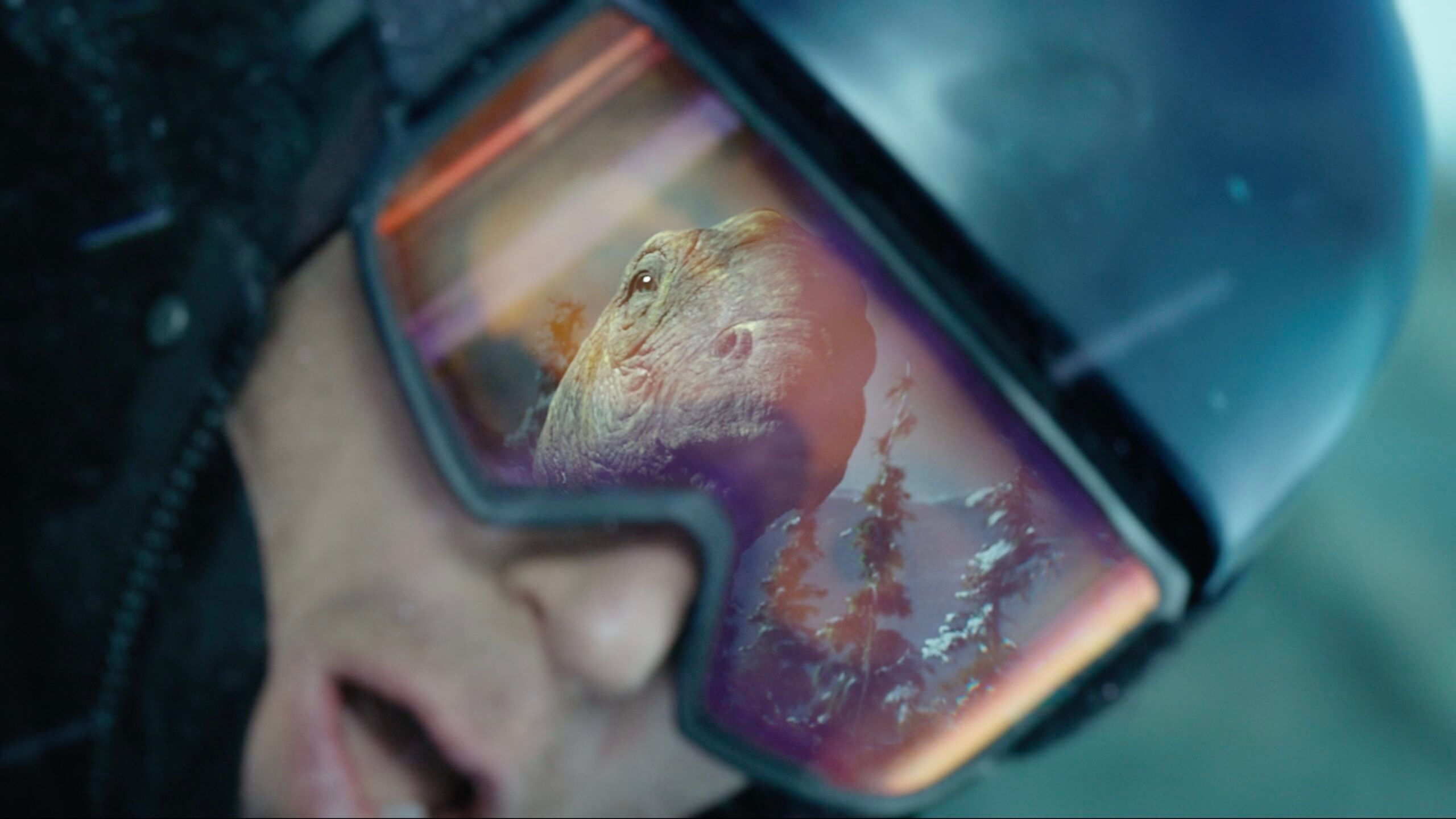Shaun White's face reflected in ski goggles with a dinosaur superimposed