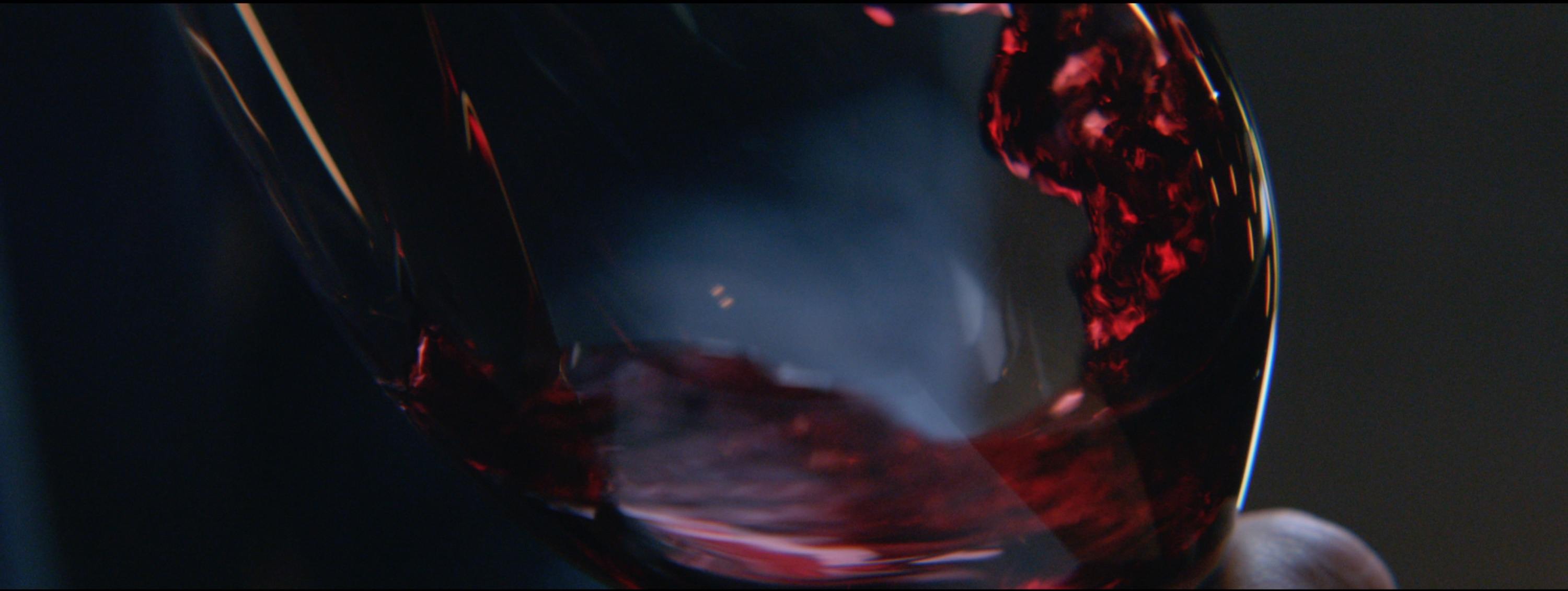 Red wine swirling in a glass, captured with cinematic lighting and depth
