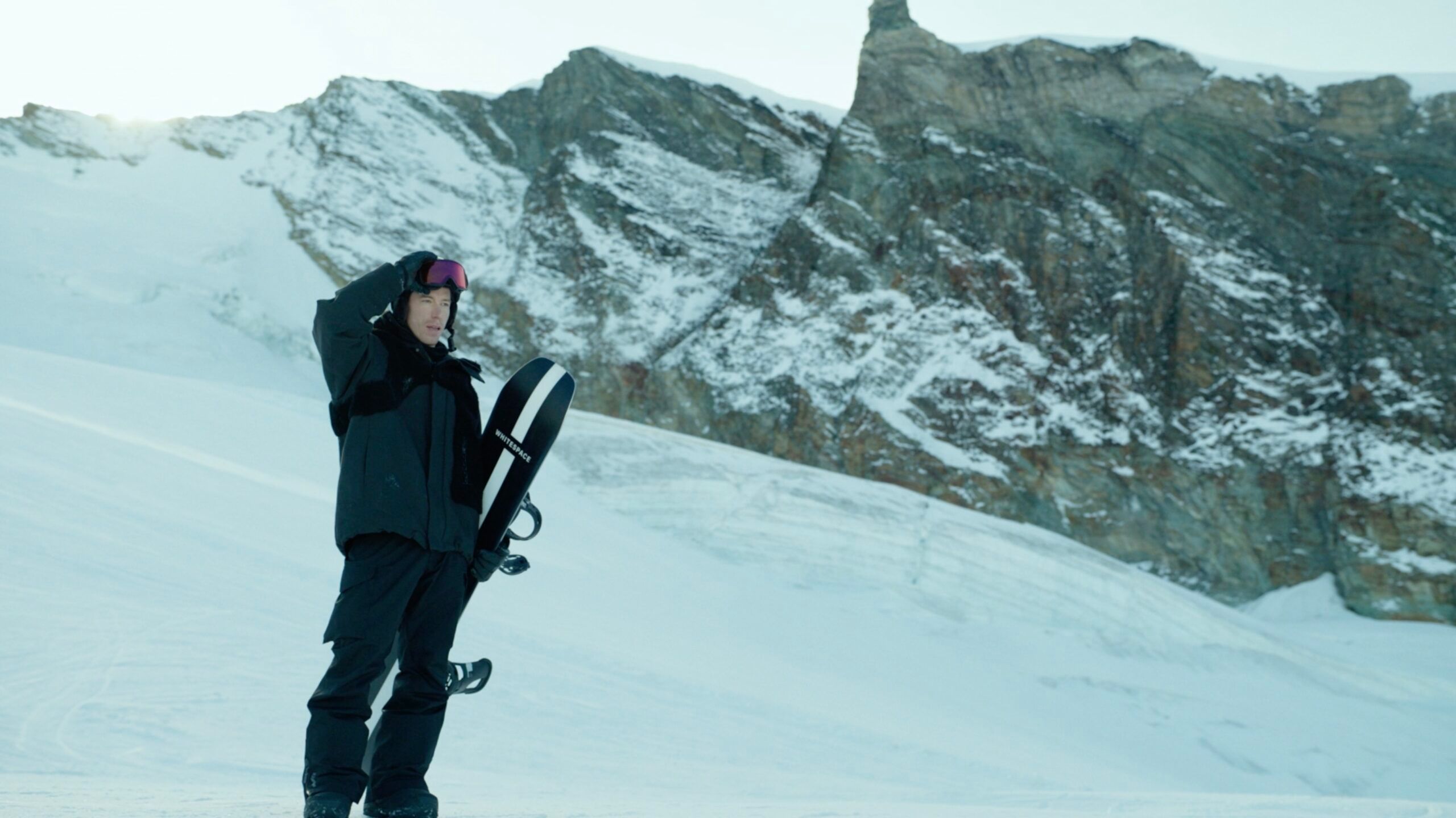 Shaun White holding snowboard in snowy mountain landscape