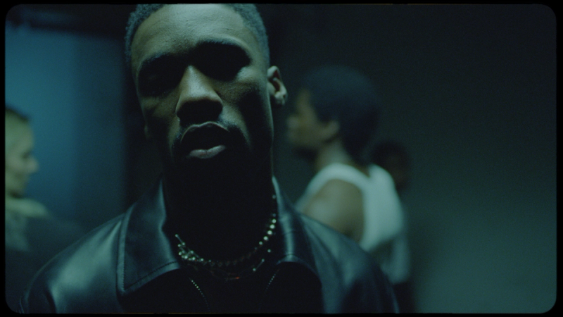 Giveon in moody cinematic portrait with leather jacket and chain necklace