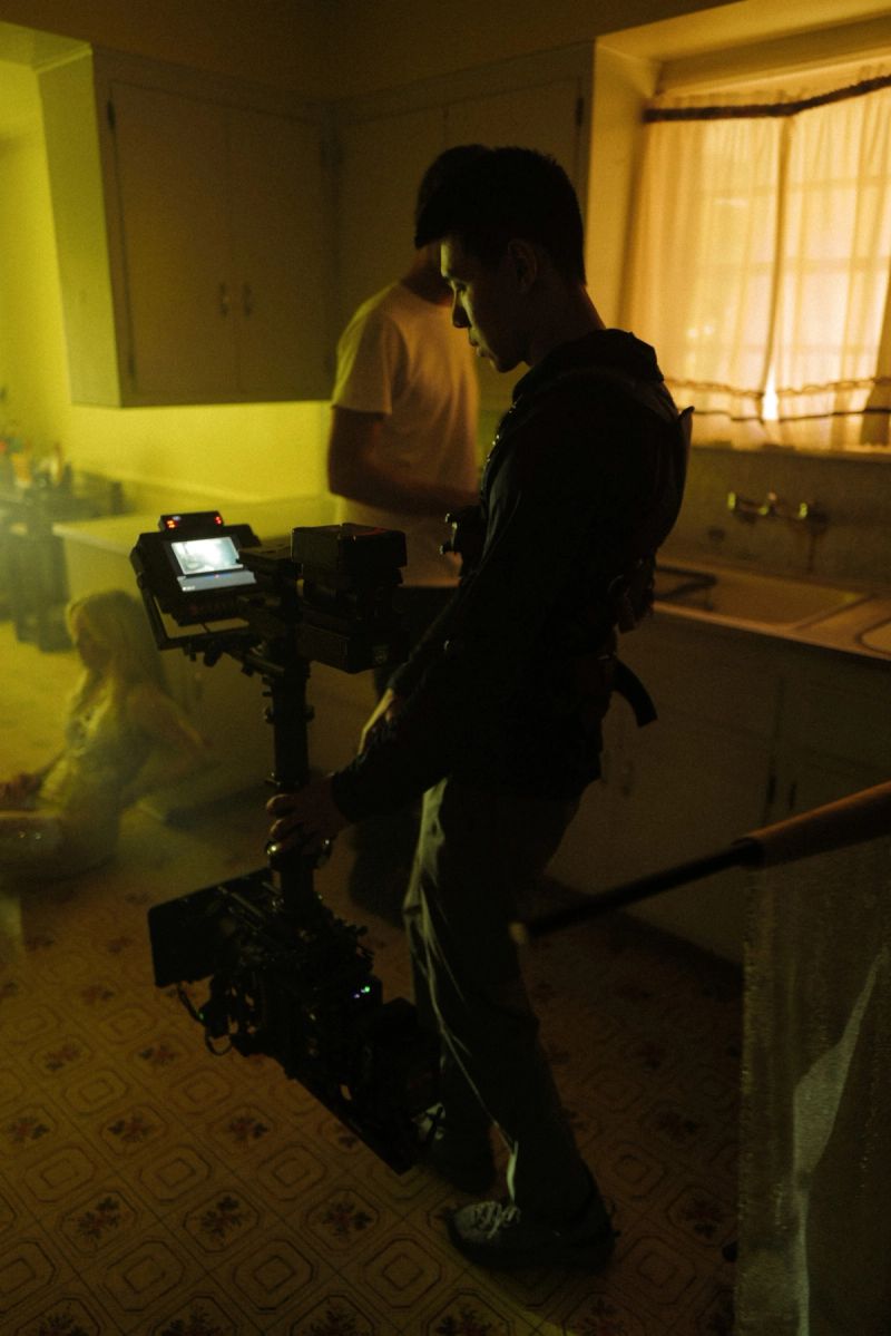 Ian Rigby operating a camera rig in a dimly lit kitchen set for Zara Larsson's 'End of Time' music video.
