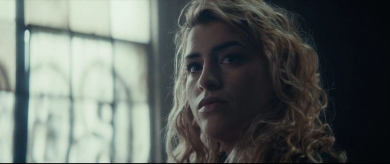 Cinematography portrait of Olympic wrestler Helen Maroulis looking contemplative near a window.