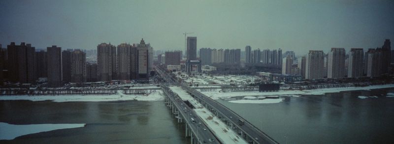 Cinematography shot of a snowy urban skyline and bridge in China for Toyota.