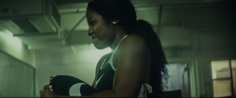 Female athlete in Nike gear stretching indoors for EastBay ConqHer Santia Deck womens football project.