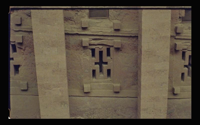 Detail of carved stone facade with geometric patterns and rectangular openings