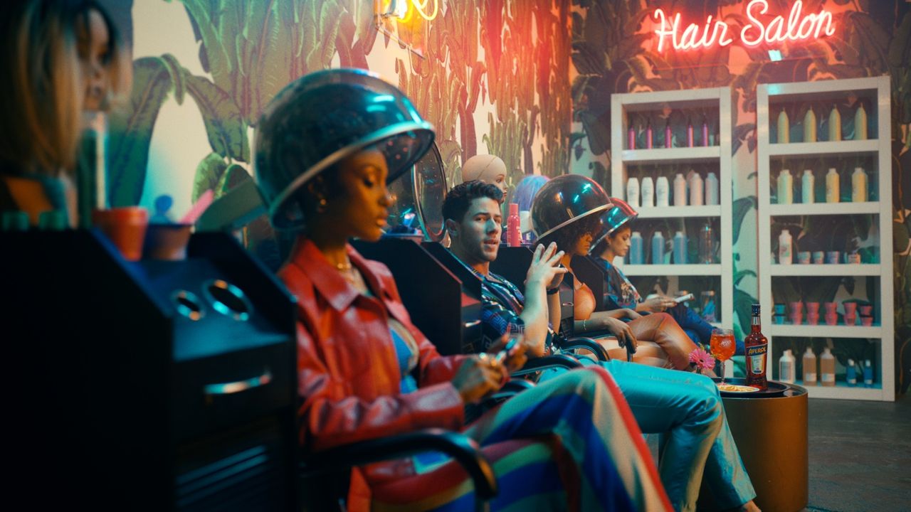 Jonas Brothers in a vibrant, neon-lit hair salon with film photography style