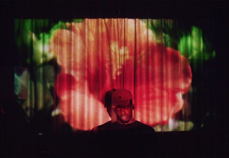 Reggie Jackson at a LA Clippers screening event with colorful abstract projection background.