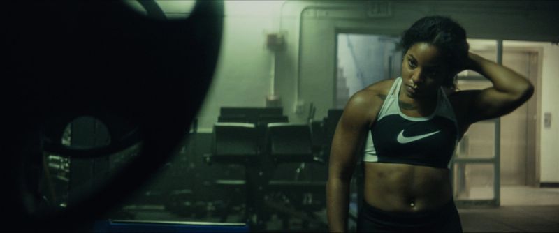 Female athlete Jen Welter pauses in a gym, wearing Nike sports bra.
