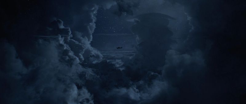 Dark storm clouds with a distant airplane silhouette against starry night sky