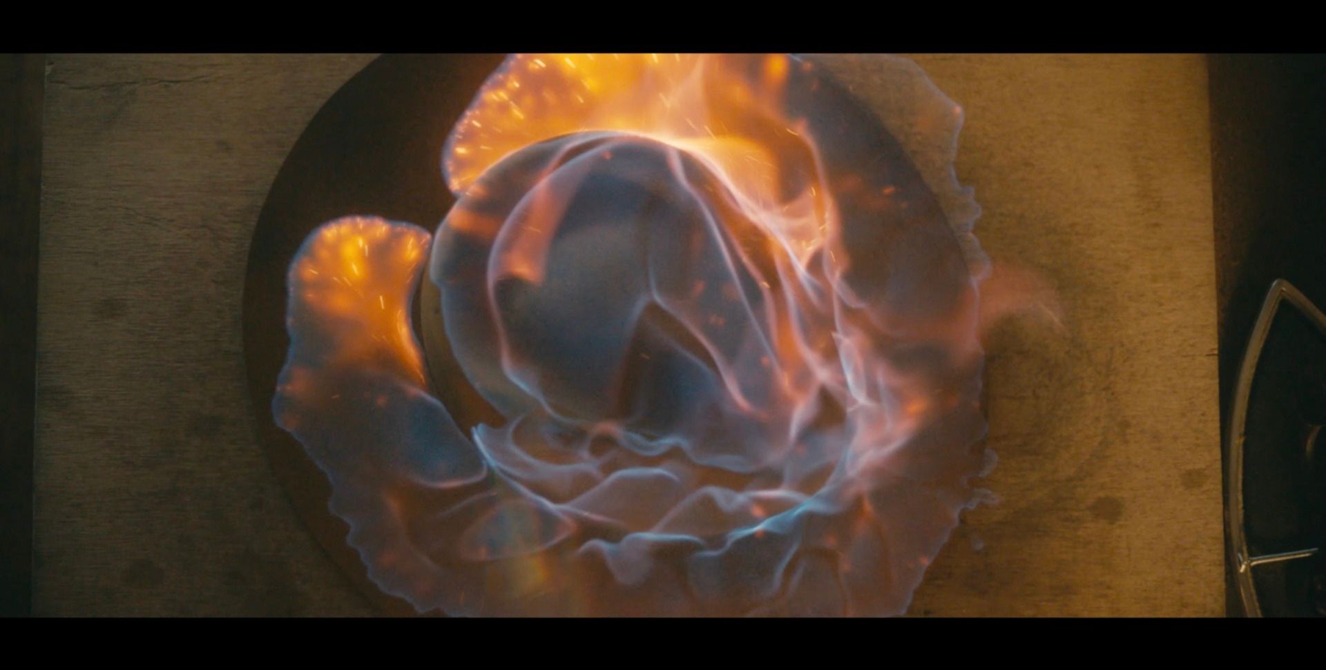 Close-up top-down view of a swirling blue and orange gas flame.
