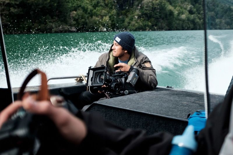 Cinematographer operating cinema camera on a boat in Patagonia, Chile for Fjallraven.