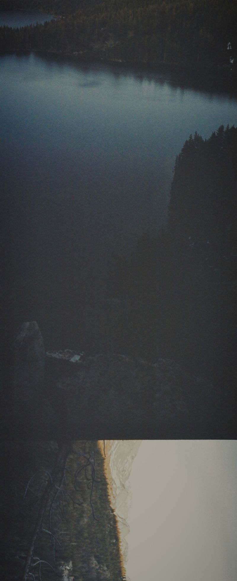 Dark moody lake landscape with forest reflections, shot on film.