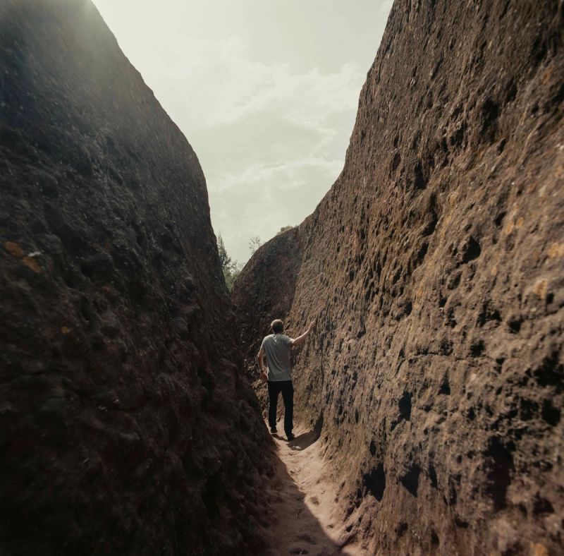 Man walking through narrow rocky canyon in Ethiopia
