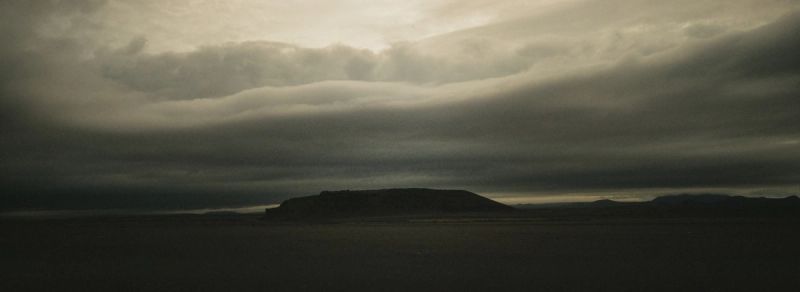 Atmospheric landscape of a mesa under heavy clouds, shot on Hasselblad XPan medium format film.