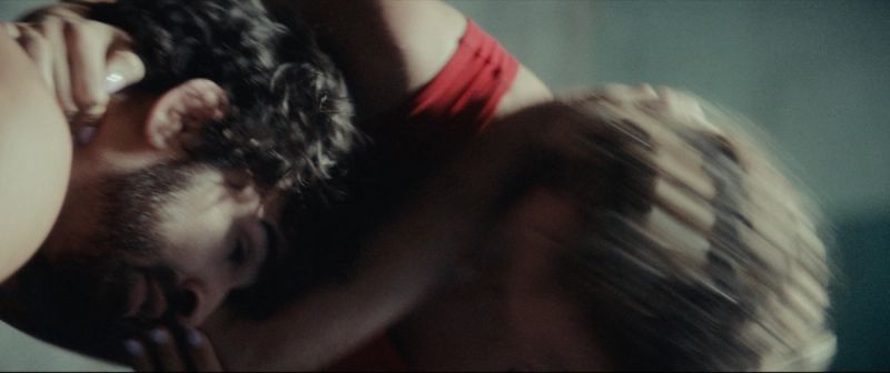 Olympic wrestler Helen Maroulis embraces a partner in an intimate, dimly lit cinematic close-up.