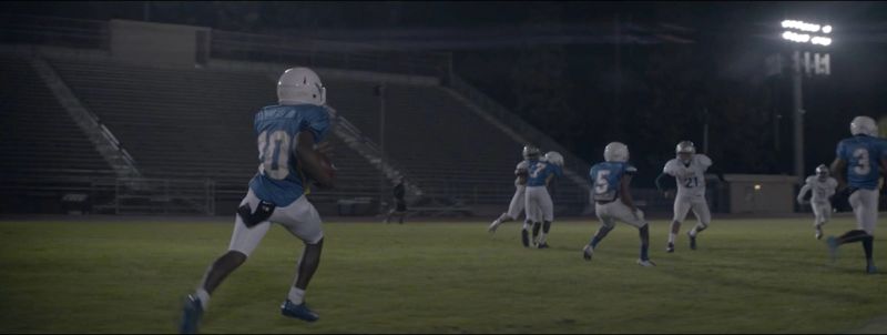 Football players in action under stadium lights at night