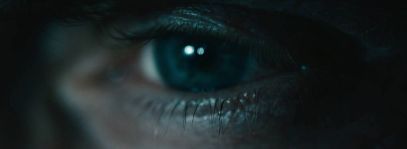 Extreme close-up of a blue eye with reflections, capturing the intensity of the iFly Skydiving VR experience.