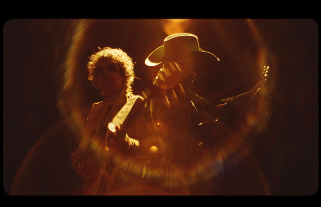 Orville Peck and Beck performing on stage with warm film lighting