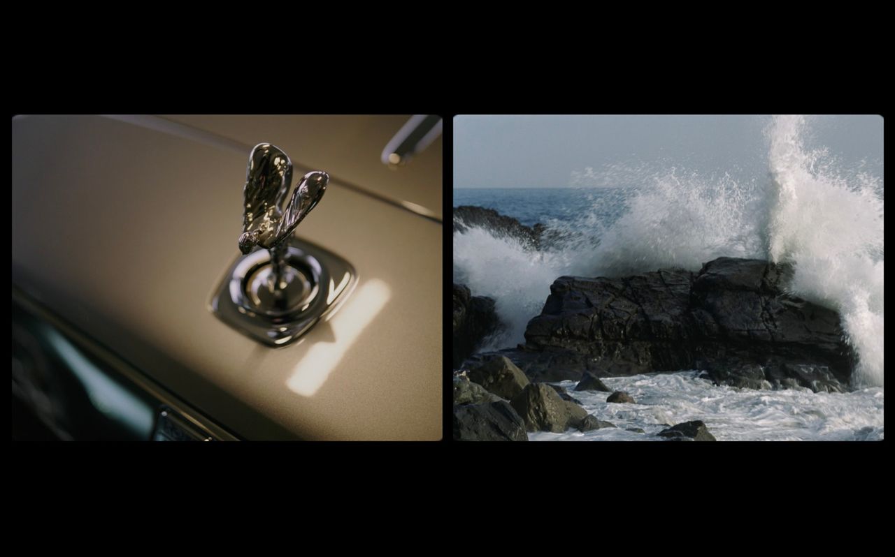 Rolls-Royce Spirit of Ecstasy emblem next to crashing ocean waves against rocks.