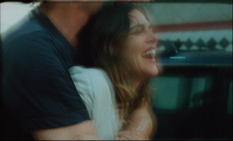 Couple laughing closely in a car, shot on film with natural lighting