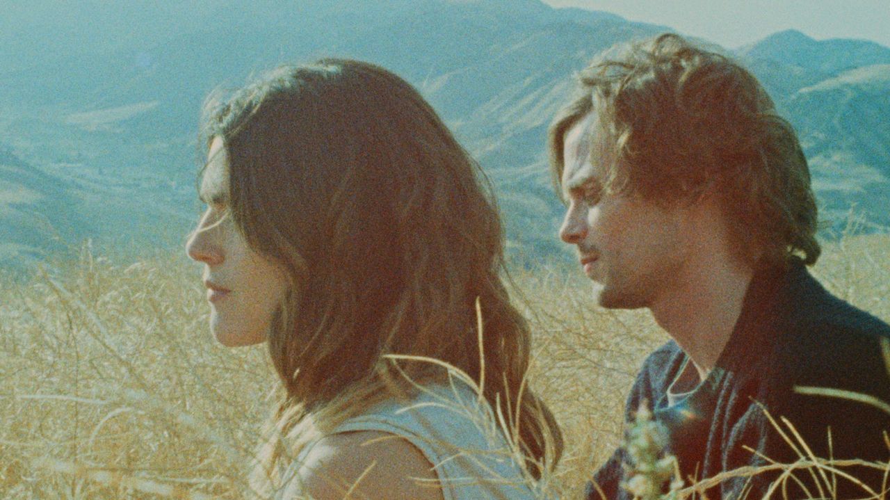 Man and woman in profile gazing at mountain landscape