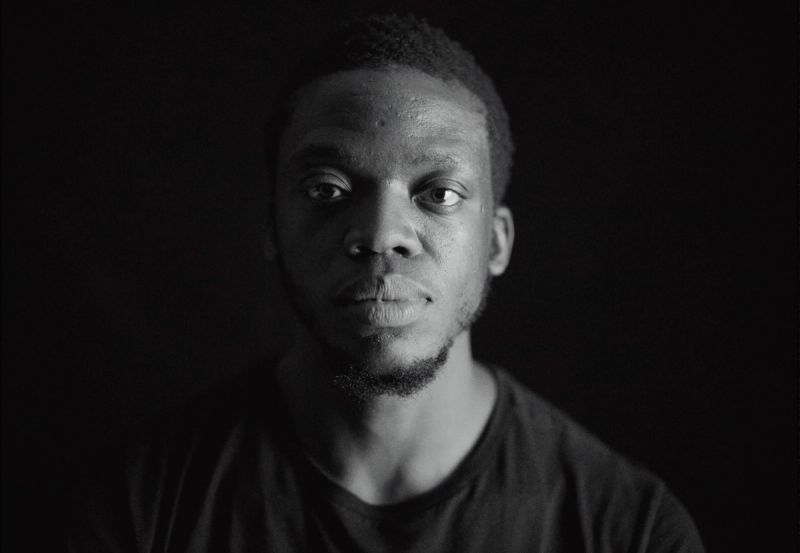 Black and white portrait of Reggie Jackson looking forward against a dark background.