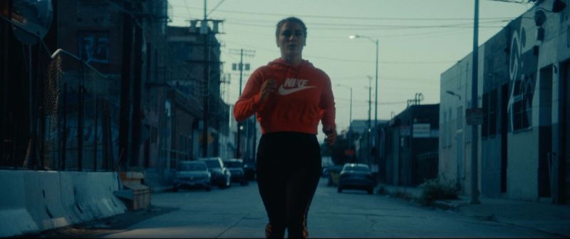 Olympic wrestler Helen Maroulis running down an urban street in an orange Nike hoodie.