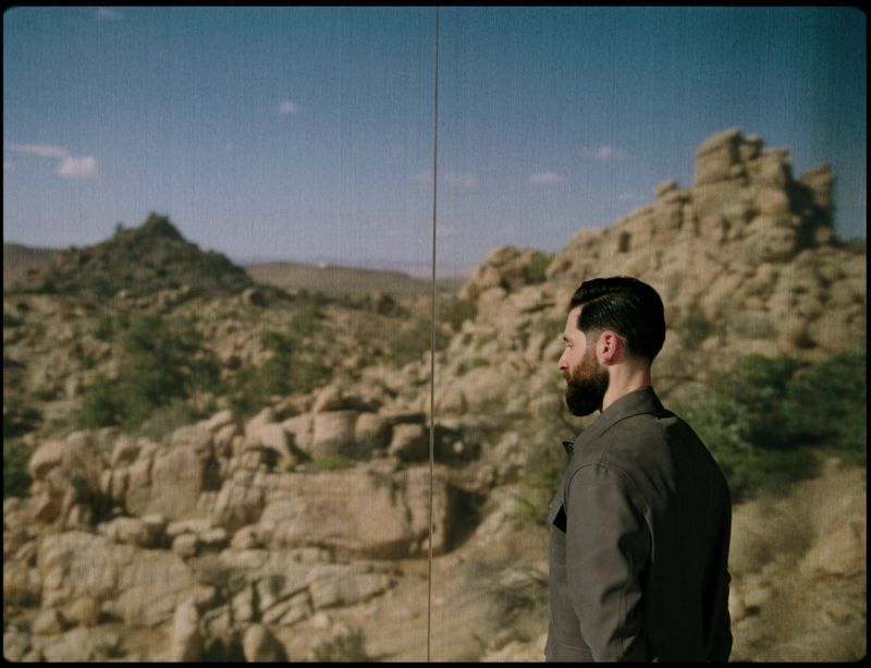 Director Alex Nazari looking out over a rocky desert landscape in the Rolls Royce Inspiring Greatness project.