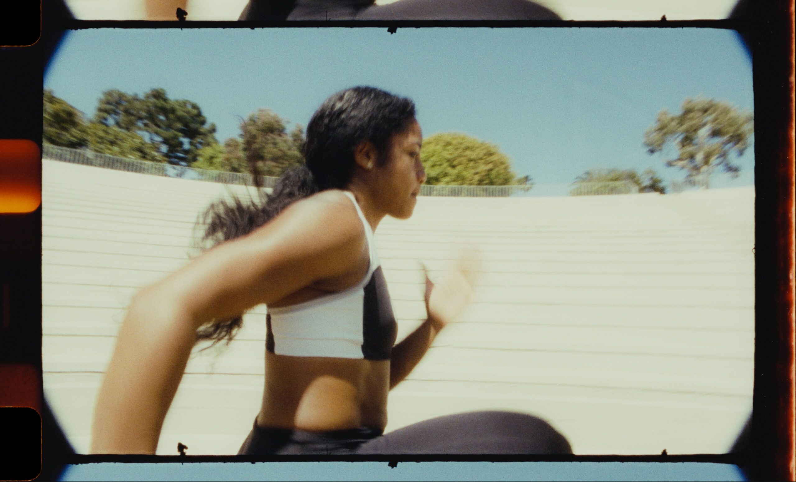 Female athlete running on stadium bleachers during EastBay ConqHer Santia Deck project.