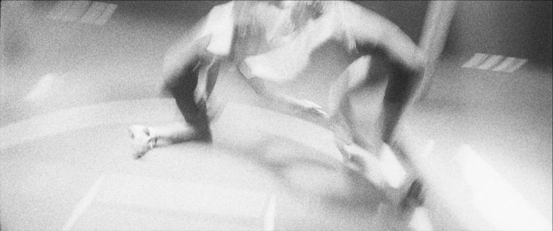 Blurred black and white action shot of Olympic wrestler Helen Maroulis grappling on the mat.