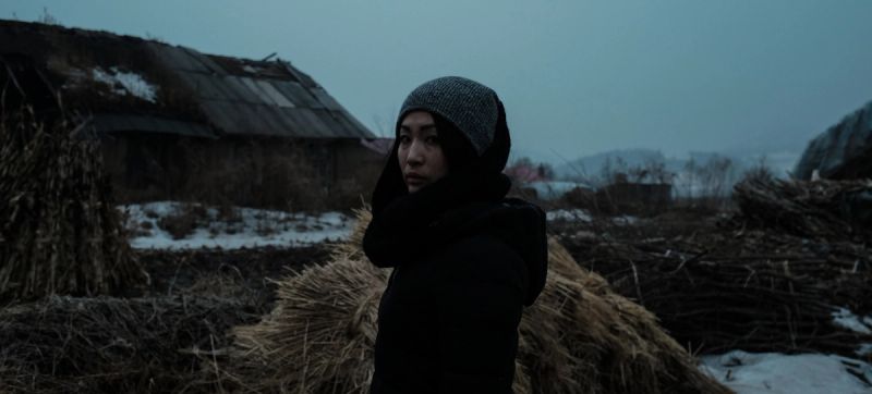 Cinematography still from Toyota Start Your Impossible project in Jilin China featuring a person standing near haystacks in rural winter.