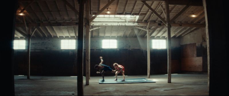 Olympic wrestler Helen Maroulis training in a warehouse with dramatic natural light streaming through windows.
