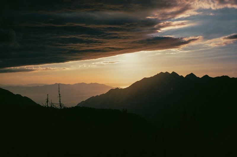 Silhouetted mountain peaks at sunset with dramatic clouds, shot on Kodak Portra 400 in Utah.