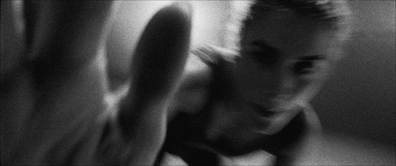 Black and white cinematography still of Olympic wrestler Helen Maroulis reaching forward in a dramatic close-up.
