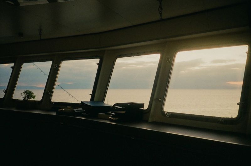 View from a boat cabin looking out at the sea and sky through windows.