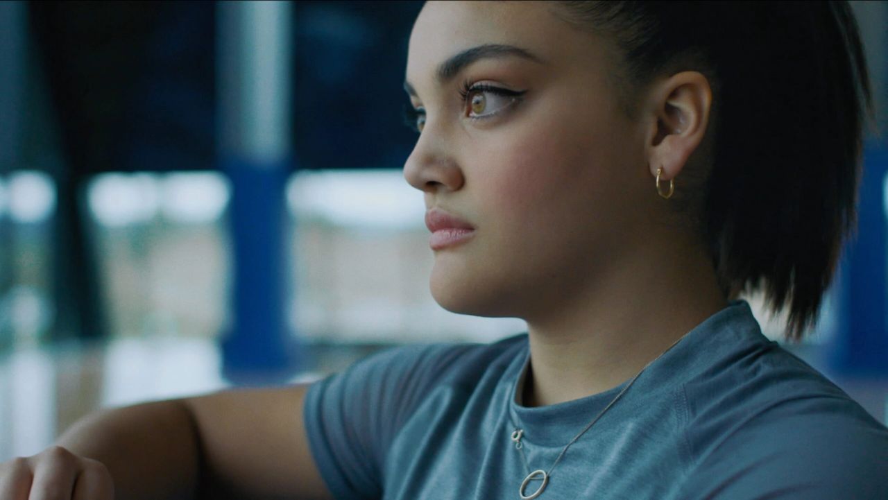 Young woman in blue shirt gazing thoughtfully, Nike Dear Nike project still