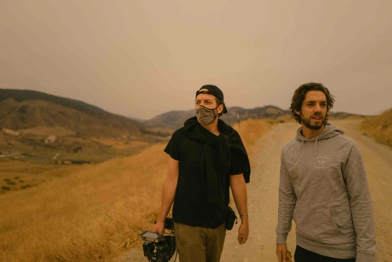 Ian Rigby and Will Mayer walking on a dusty trail in hazy mountain landscape