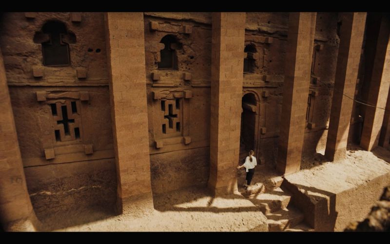 Woman walking through ancient stone columns in Ethiopia