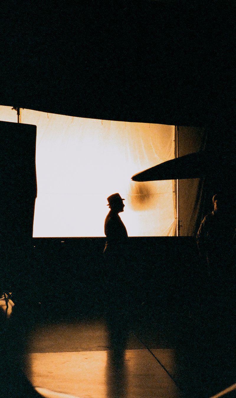 Silhouette of a person in front of bright film-lit backdrop on set