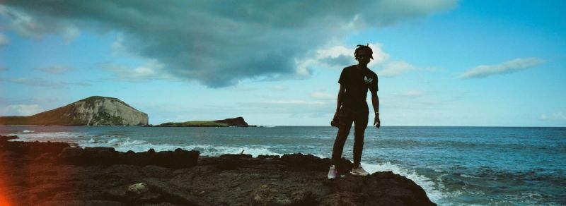 Cinematographer Will Mayer stands on rocky shore in Hawaii for Nike environmental project
