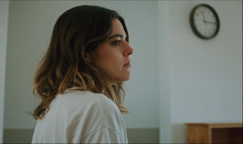 Woman in white shirt looking thoughtfully to the side