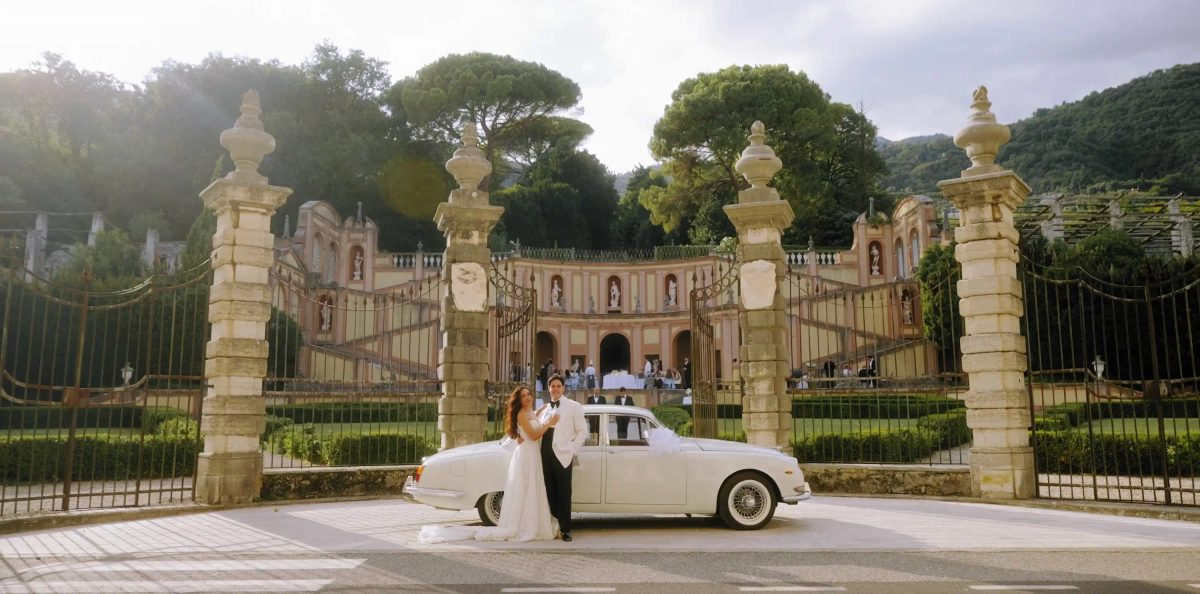 Vintage wedding car at the ornate stone gates of Villa Bettoni on Lake Garda, Italy