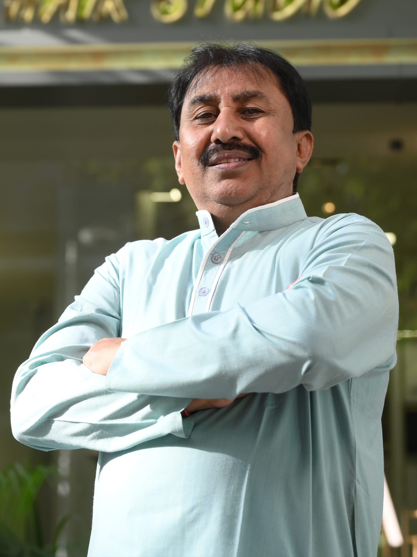 Ratilal Limbachiya, founder of Monarch Hair Studio, standing outside the studio
