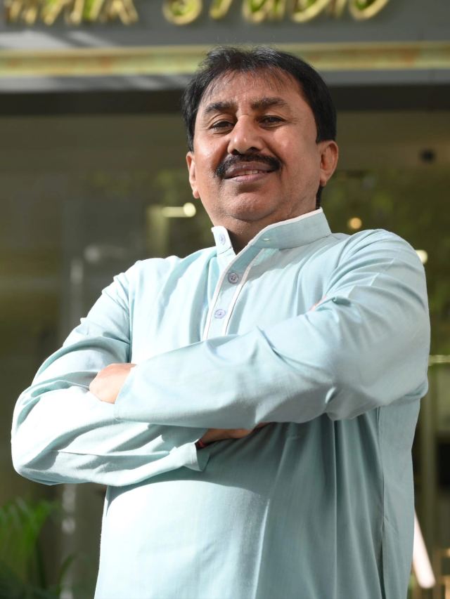 Ratilal Limbachiya, founder of Monarch Hair Studio, standing outside the studio