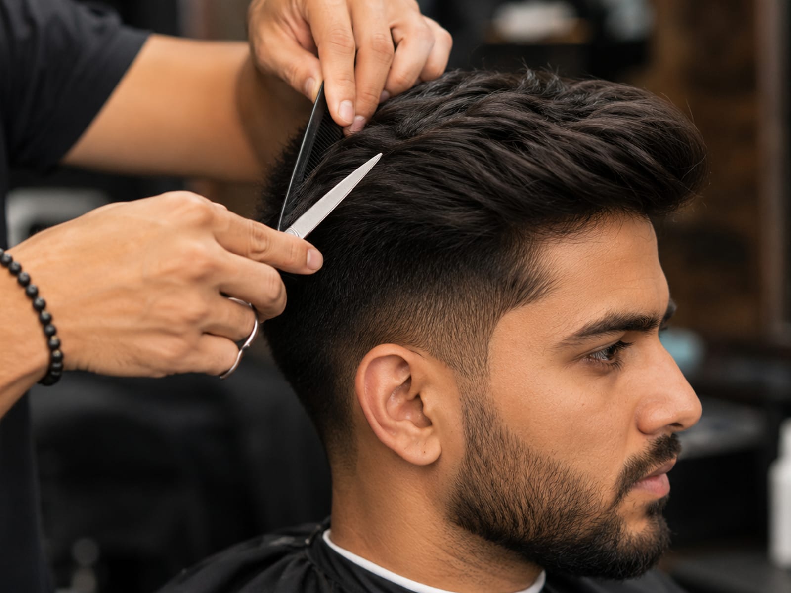 A men's haircut being cut with scissors and comb above a skin fade