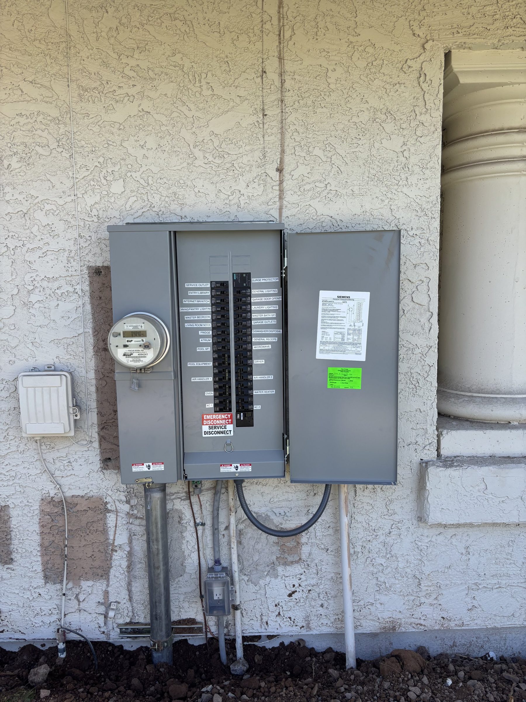 Siemens meter-main panel with open door and inspection tag on a stucco wall