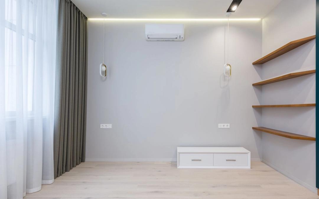 A wall-mounted ductless mini-split above an empty room with wood shelves and pendant lights