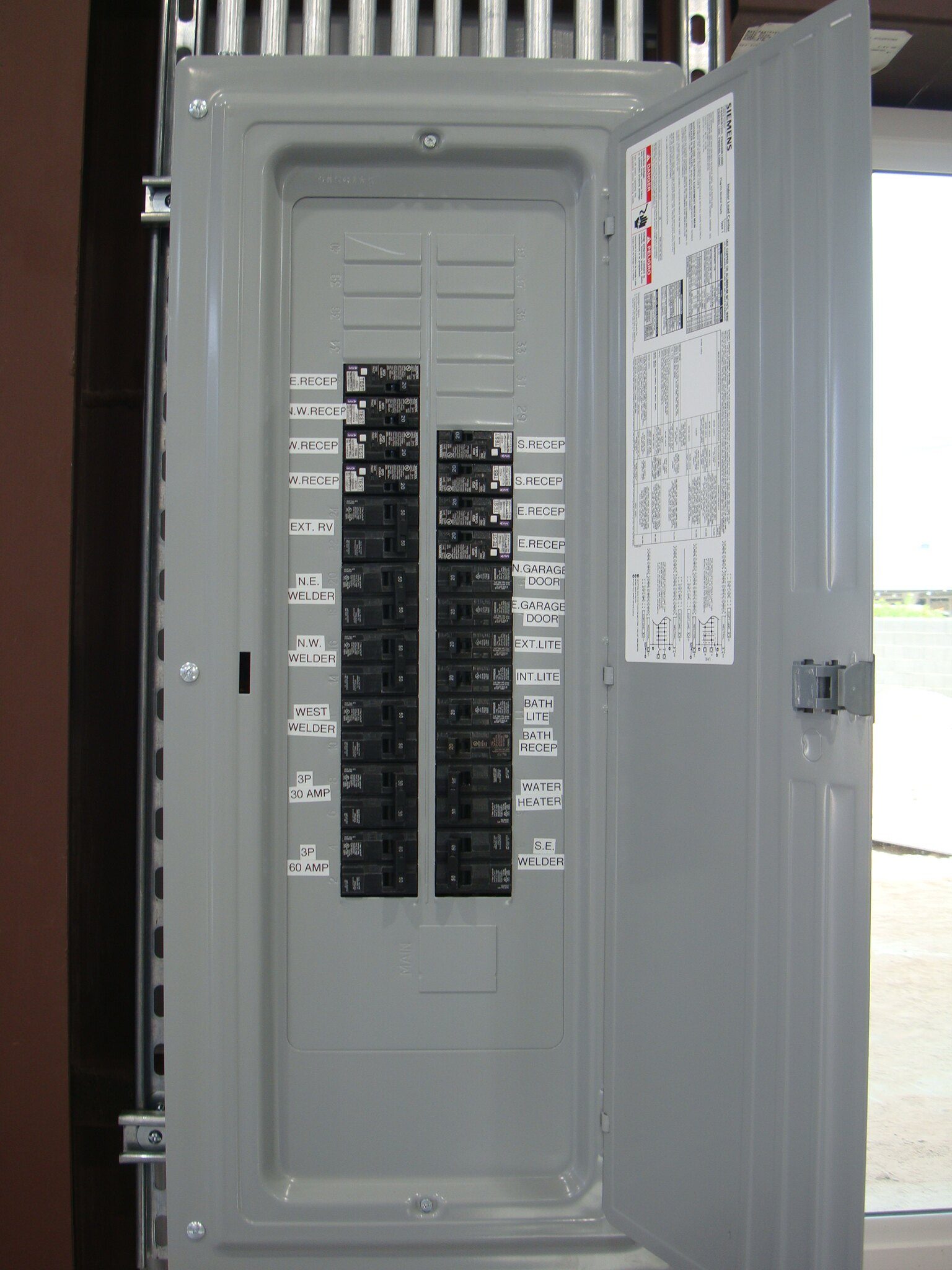 New breaker panel with neatly printed circuit labels including welder circuits