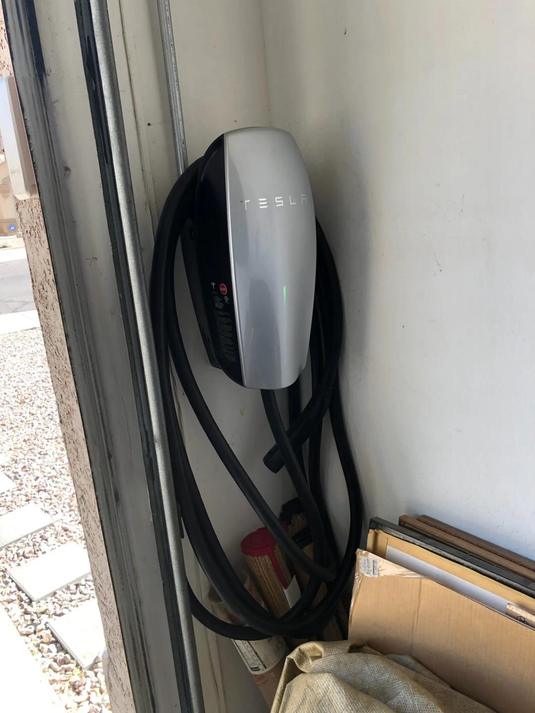 A Tesla Wall Connector installed on a garage wall
