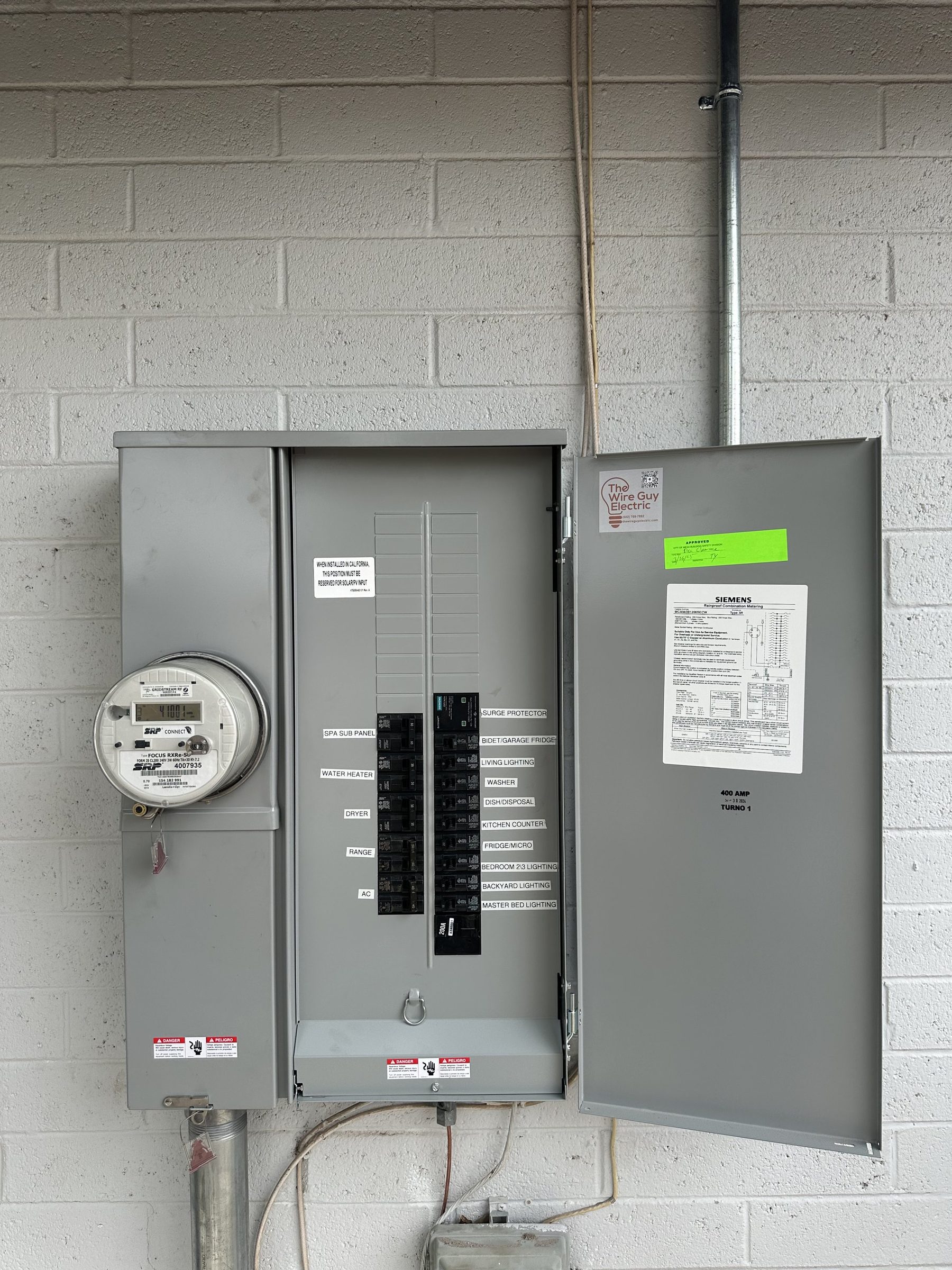 New Siemens meter-main panel with printed labels and a Wire Guy Electric sticker on the door